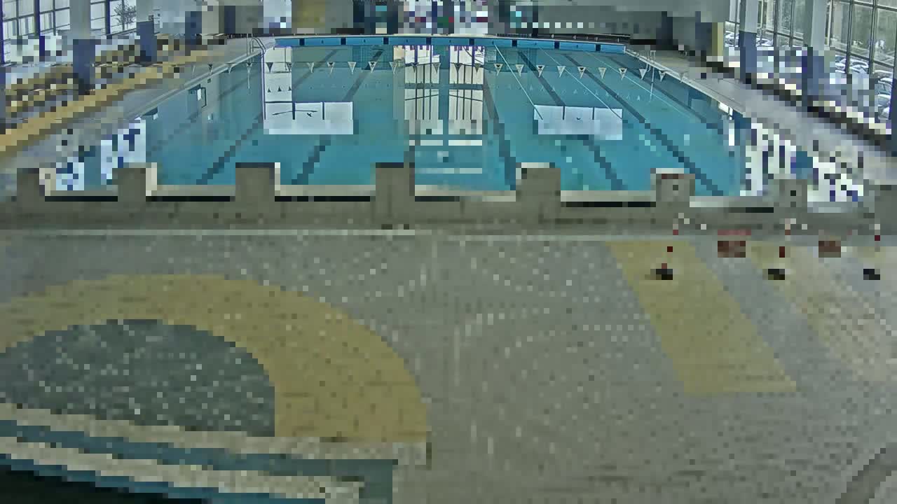 An indoor swimming pool with several people swimming in it.