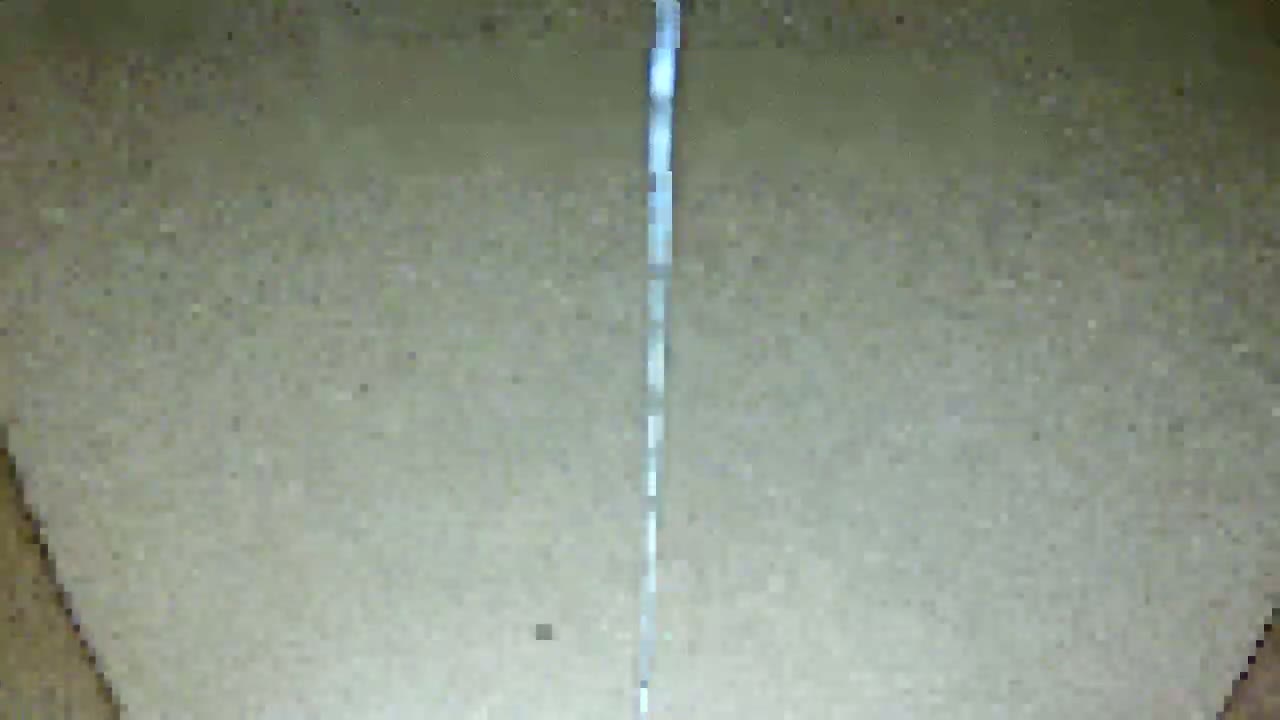 A thin, vertical, light-colored line is visible against a light beige, textured background.