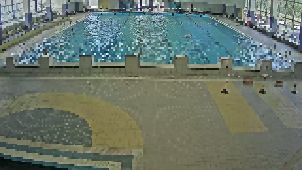 An indoor swimming pool with many people swimming.