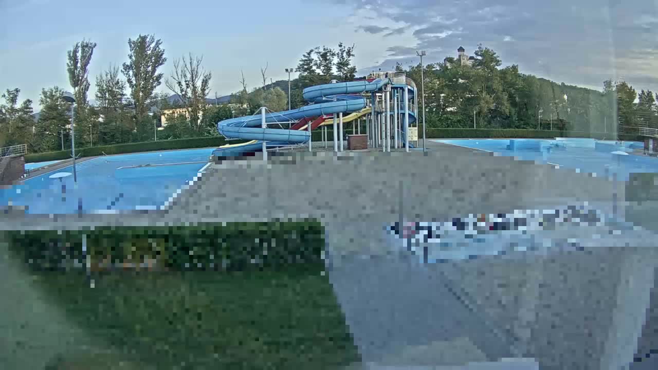 An outdoor pool complex with multiple water slides is shown on an overcast day.