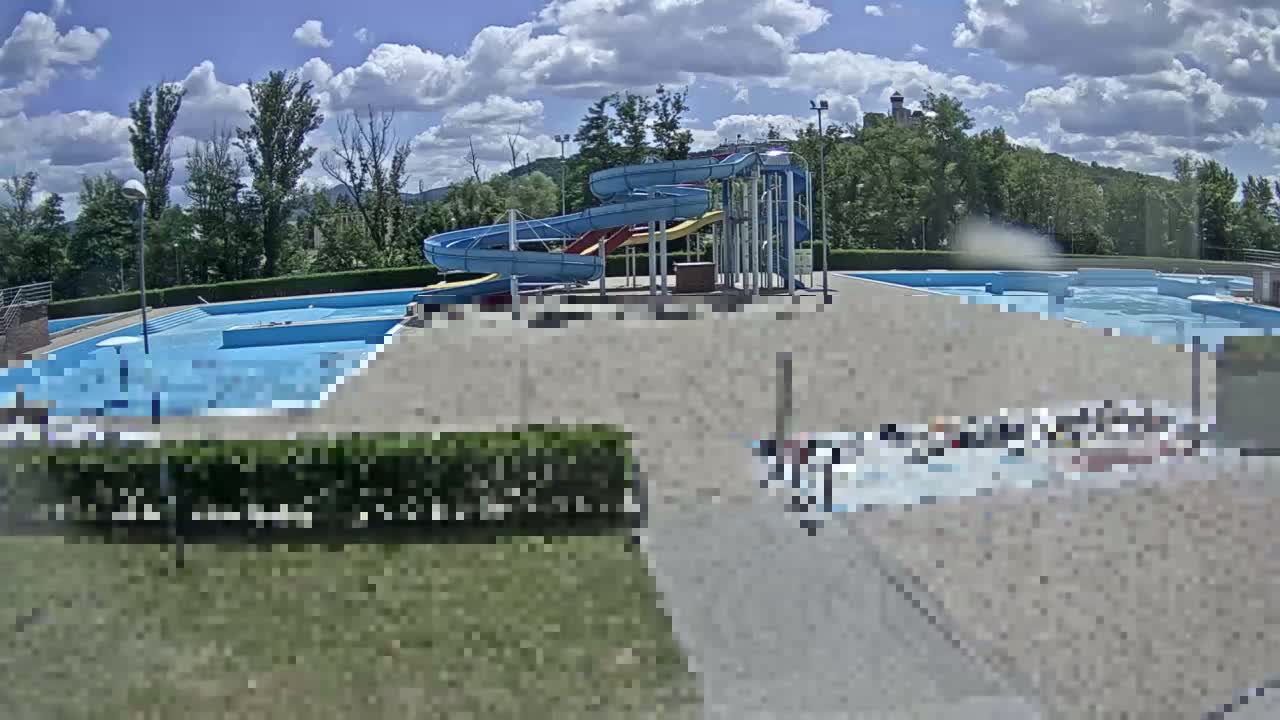 A sunny outdoor water park with multiple pools and several twisting water slides.