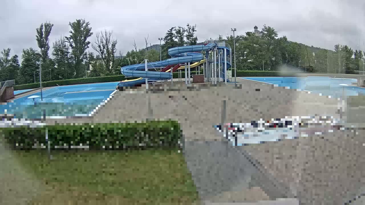 A swimming pool complex with water slides is seen on an overcast day.