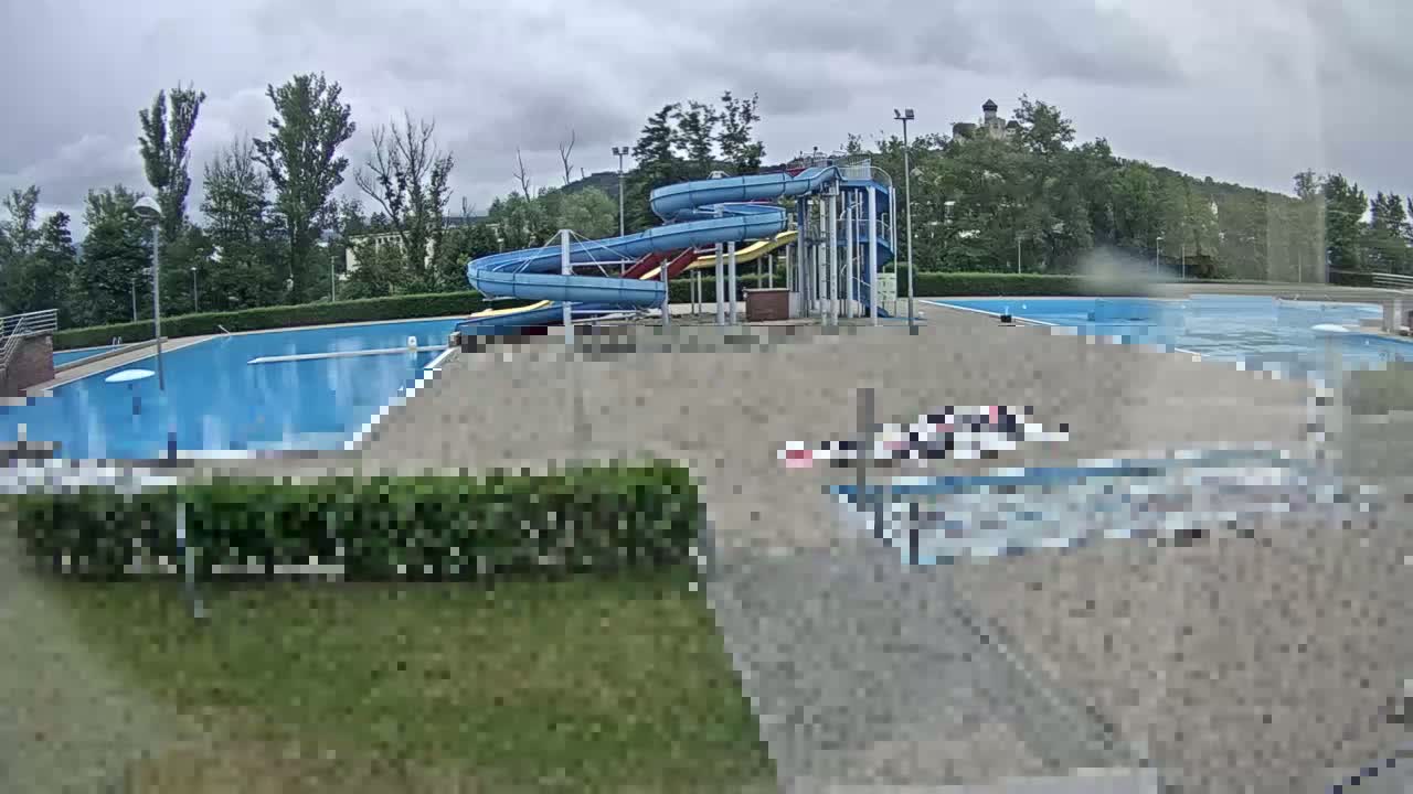 A swimming pool complex with water slides is visible on an overcast day.