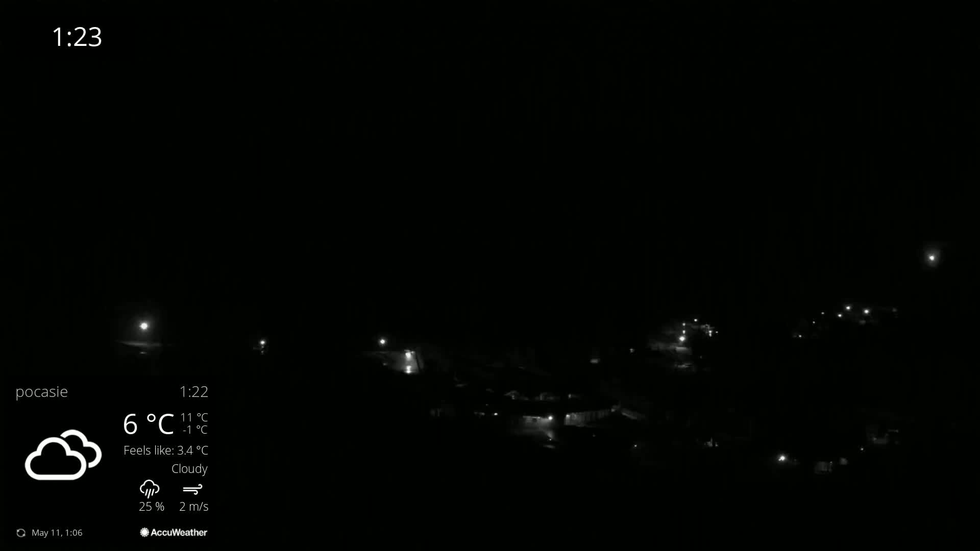 A nighttime, cloudy view of a small town with scattered lights.