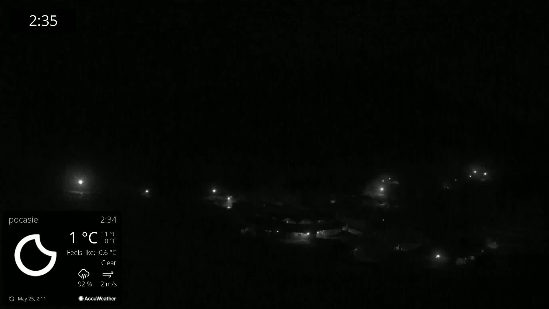 A nighttime long shot of dimly lit buildings under a clear sky.