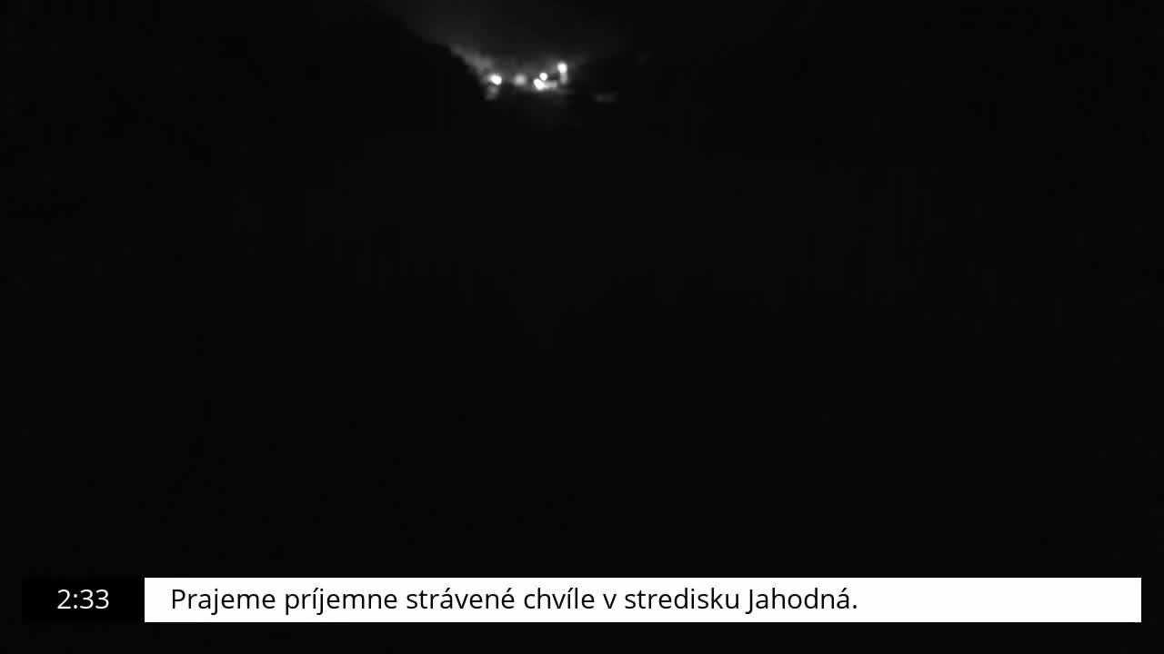 A blurry, nighttime image shows a few distant lights in the darkness.