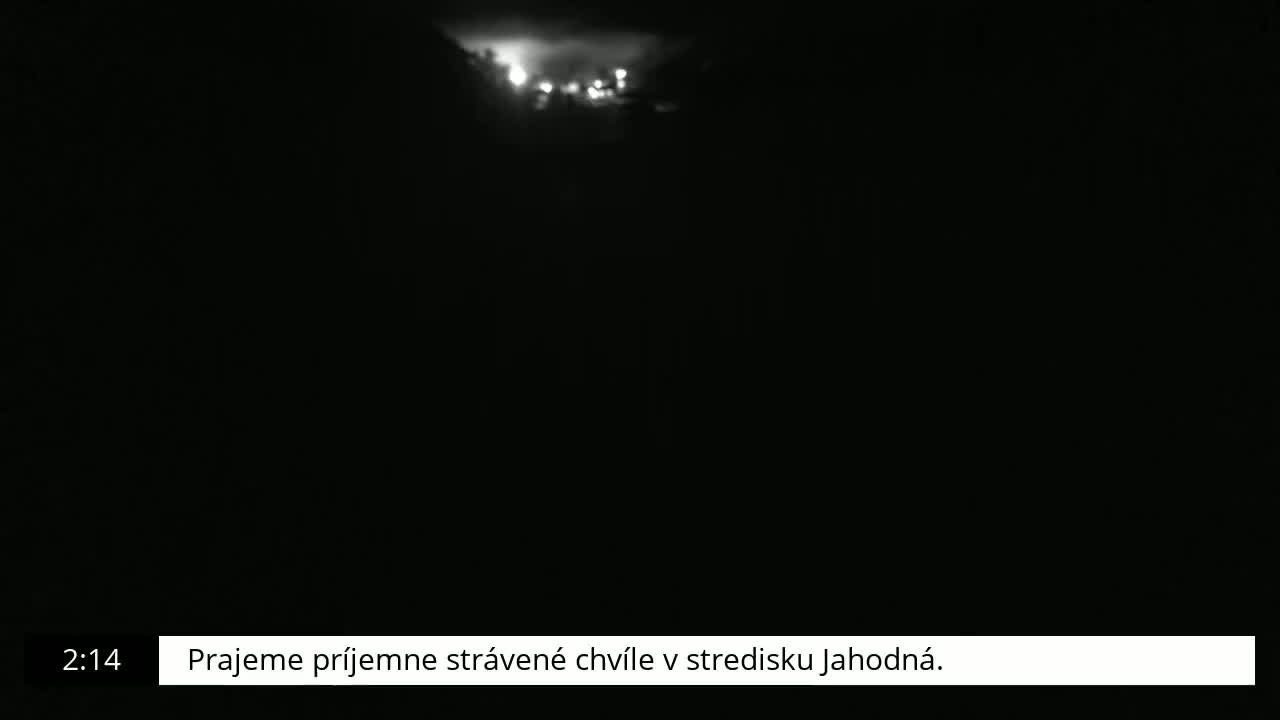 A nighttime, low-light view shows a cluster of faint lights in the distance.