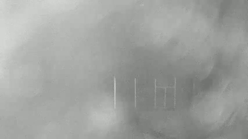A hazy, gray outdoor scene shows faint, vertical lines etched into a surface.