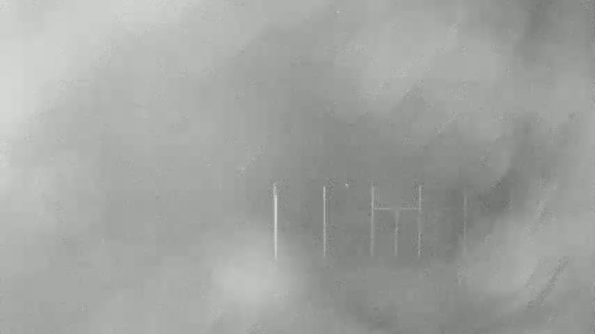 A blurry, gray image shows a few vertical lines faintly visible through a thick fog.