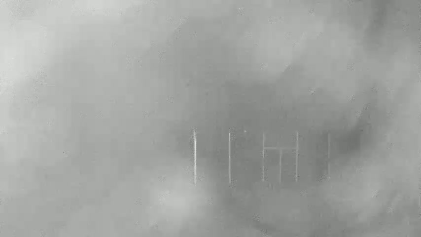 A blurry, hazy grayscale image shows faint vertical lines suggesting a structure in the distance.