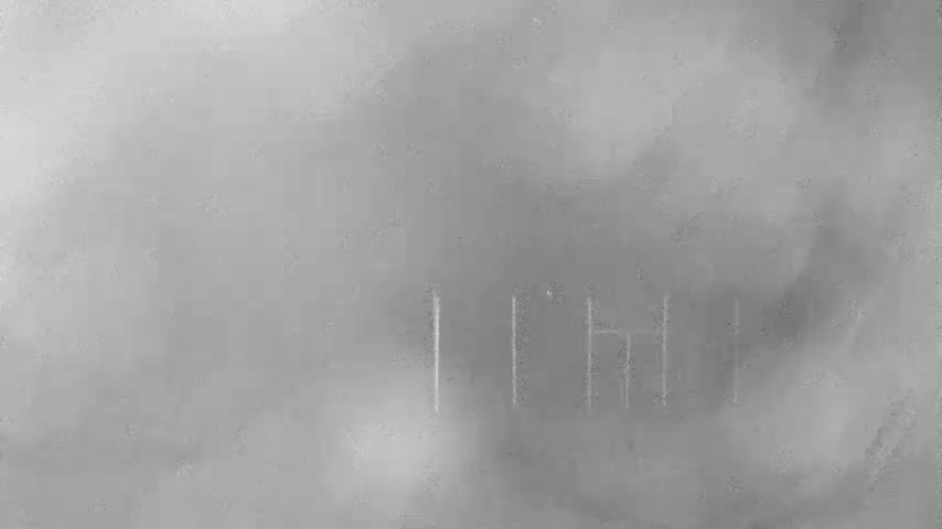 A blurry, gray image shows faint vertical lines against a foggy background.