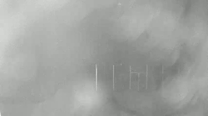 A blurry, gray image shows faint, vertical lines suggesting a structure through a hazy or foggy atmosphere.