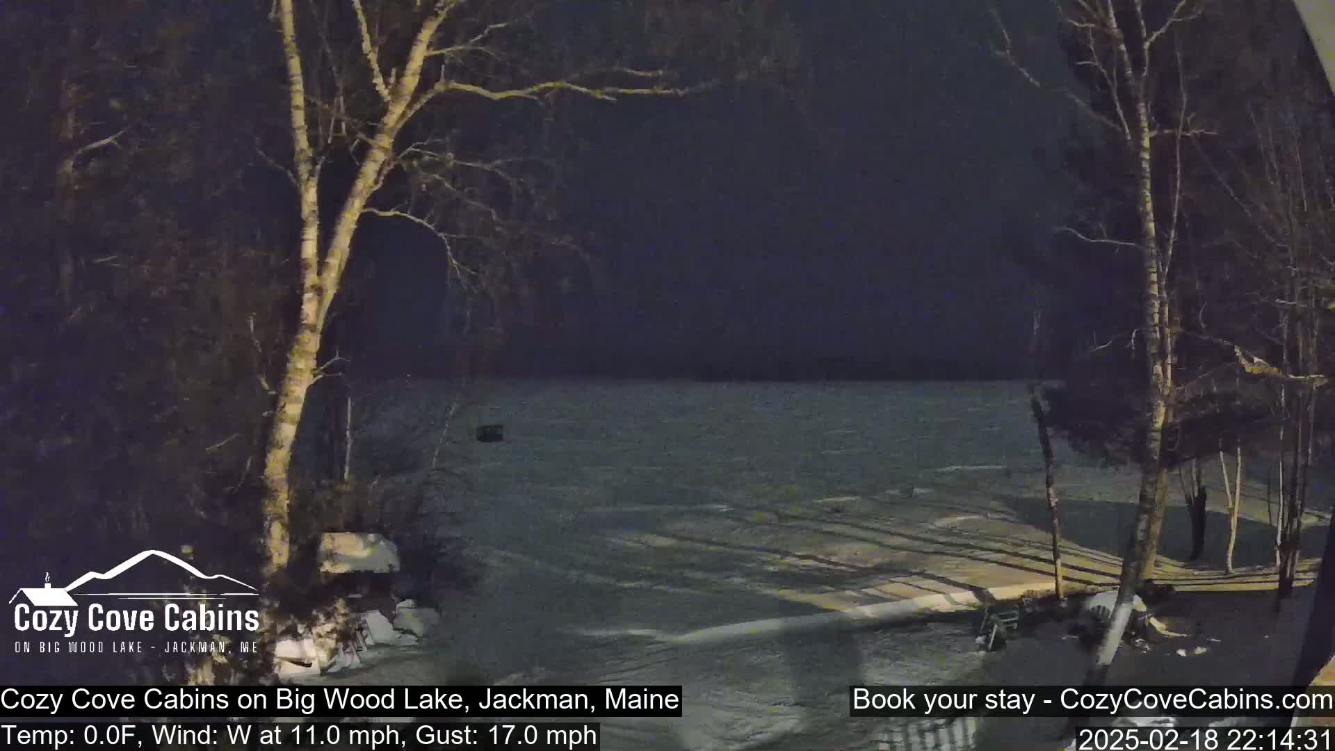 A nighttime view of a snow-covered lake under a dark sky with a 0°F temperature and a westerly wind gusting to 17 mph.