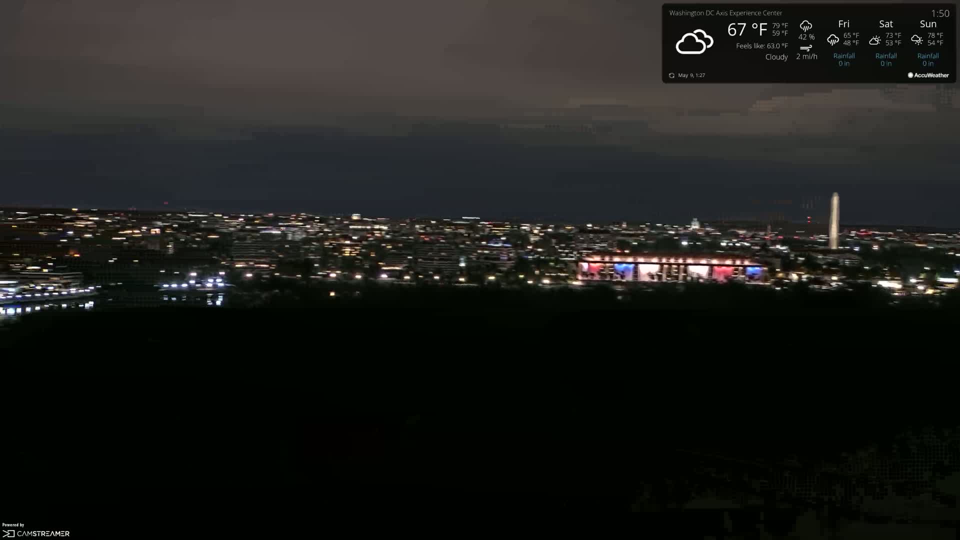 A nighttime view of a city skyline under cloudy skies.