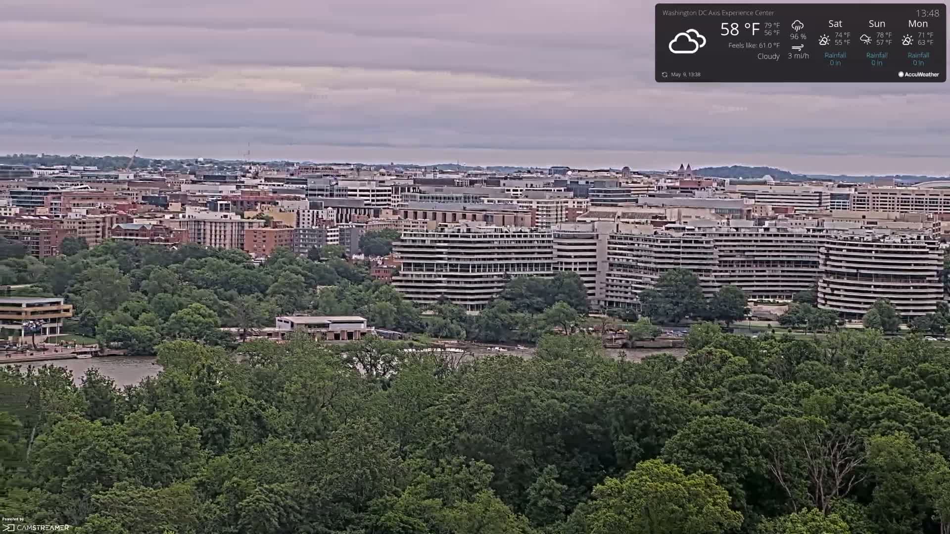 A cloudy, 58°F day overlooks a cityscape and river, densely surrounded by lush green trees.