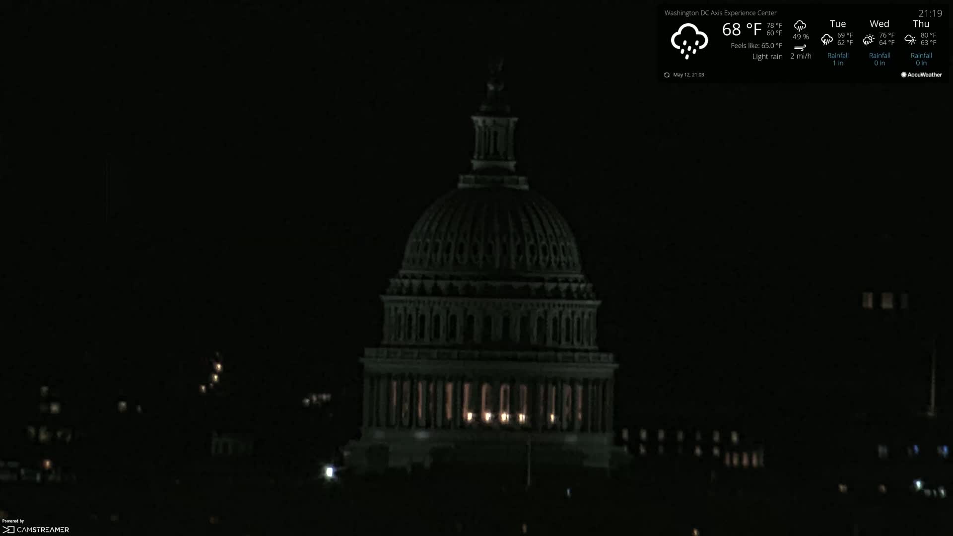 At night, under light rain, the United States Capitol building is dimly lit.