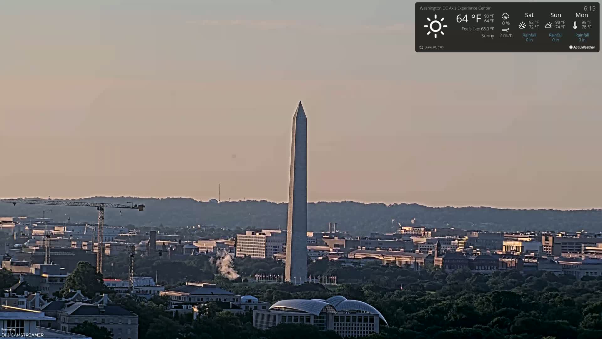A long, slender monument stands tall amidst a city skyline on a sunny day with a light breeze.