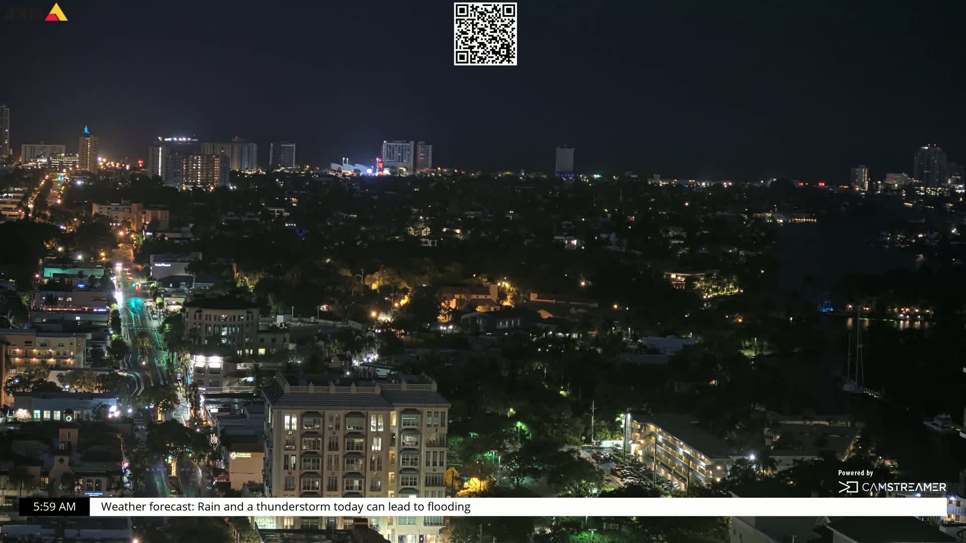 A nighttime aerial view of a city with rain and thunderstorms predicted.