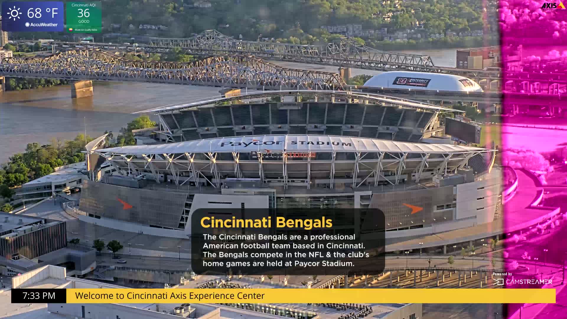 An aerial view shows Paycor Stadium on a partly sunny day, with a river and bridge in the background.