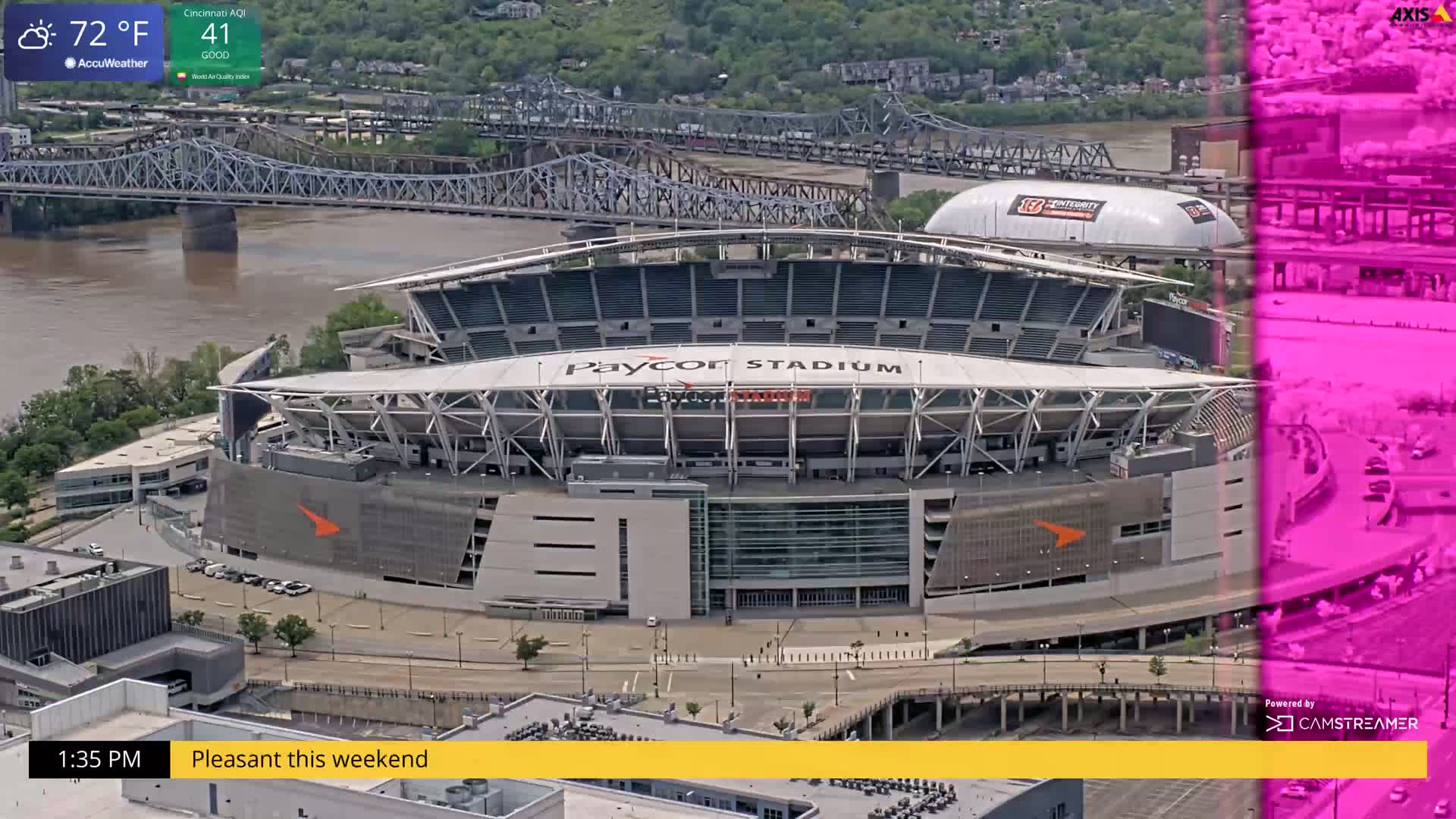 An aerial view shows Paycor Stadium on a partly sunny day, with a river and bridge in the background.