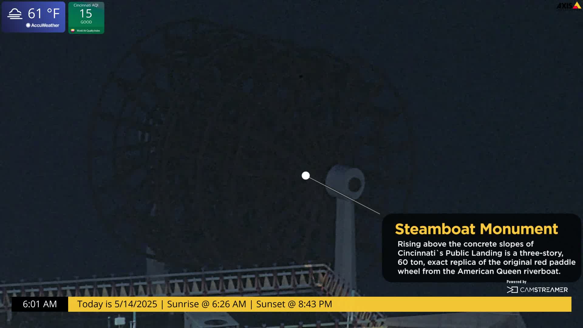 A nighttime, low-angle view shows a large, dark, three-story paddle wheel structure against a dark sky.