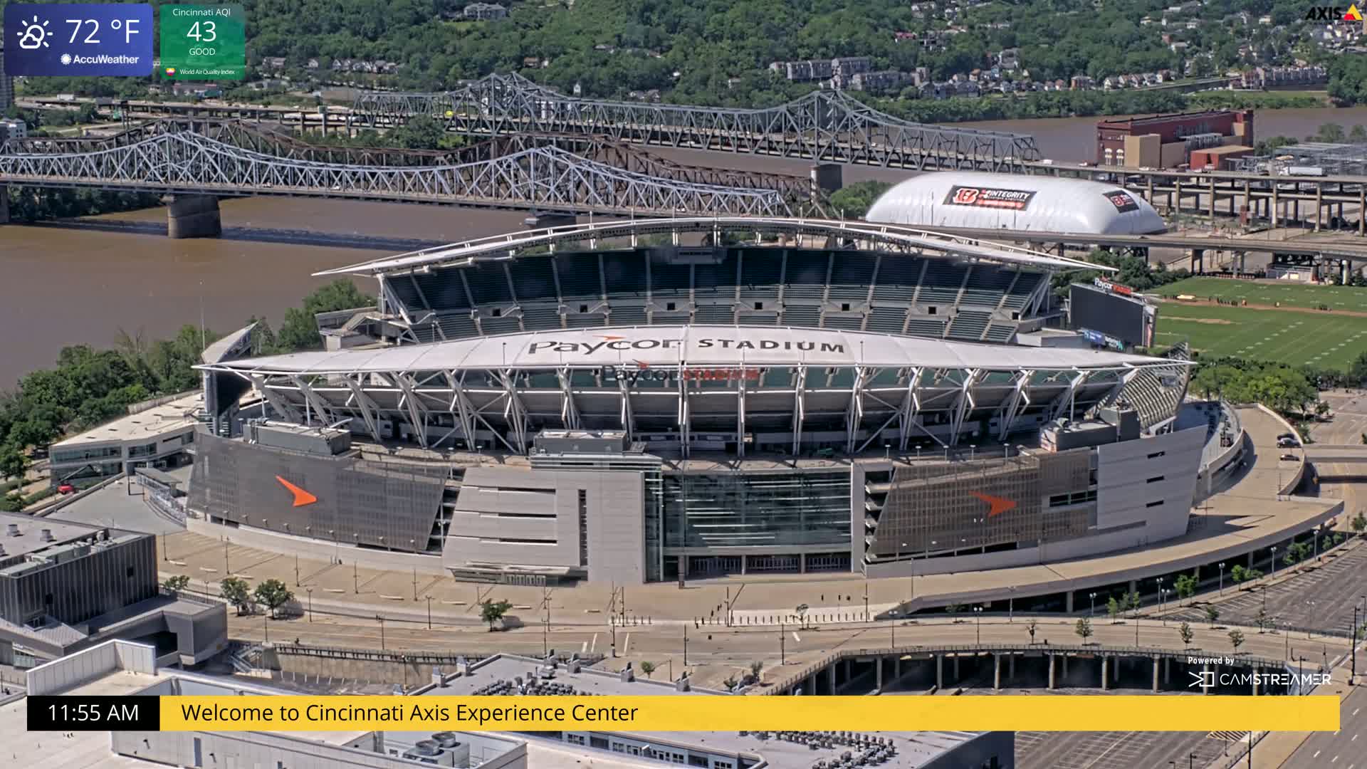 A high-angle view of Paycor Stadium on a partly sunny day, with a river and bridges in the background.