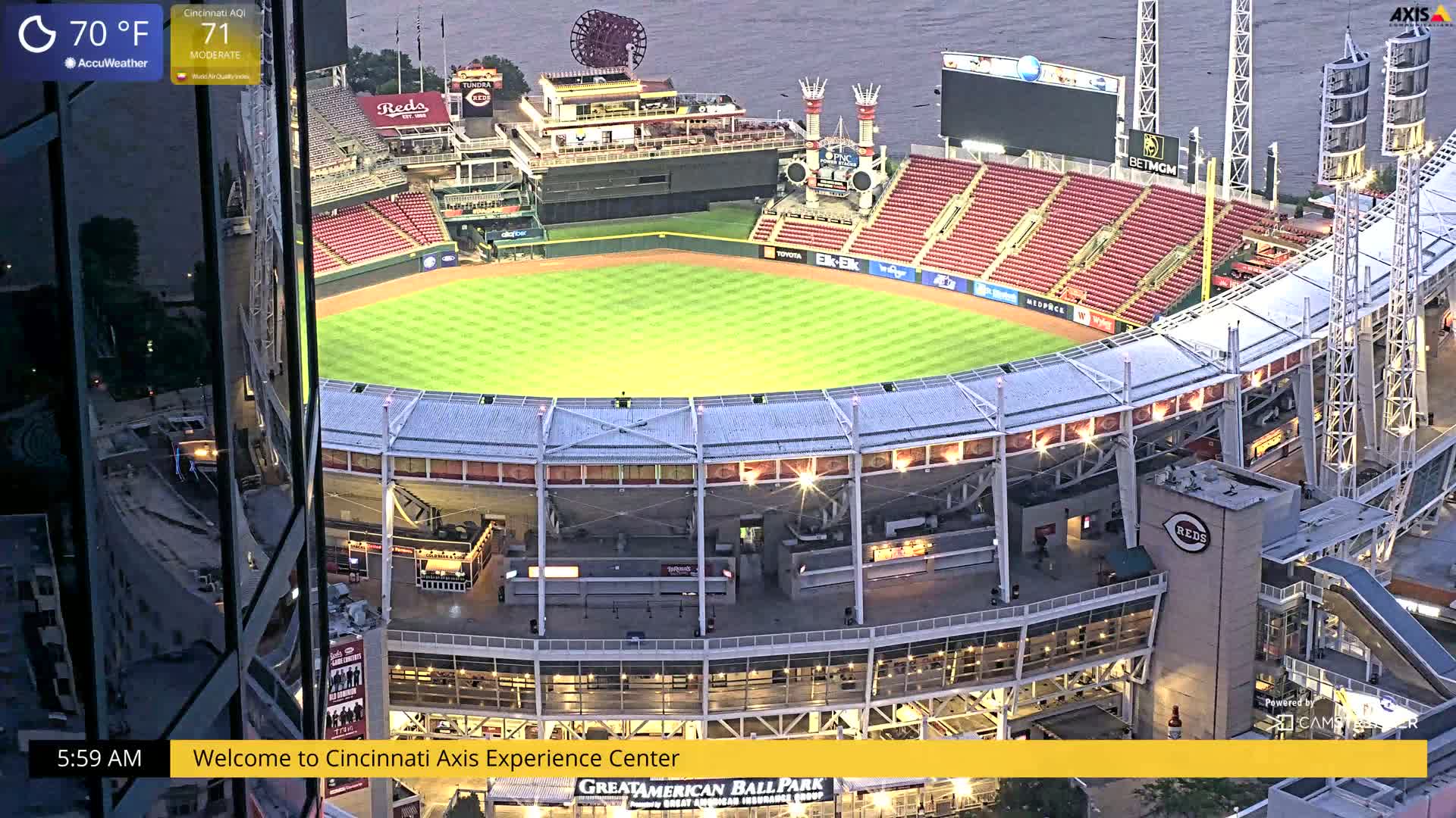 A high-angle, nighttime view of a baseball stadium under a mostly clear sky, with a body of water visible in the background.