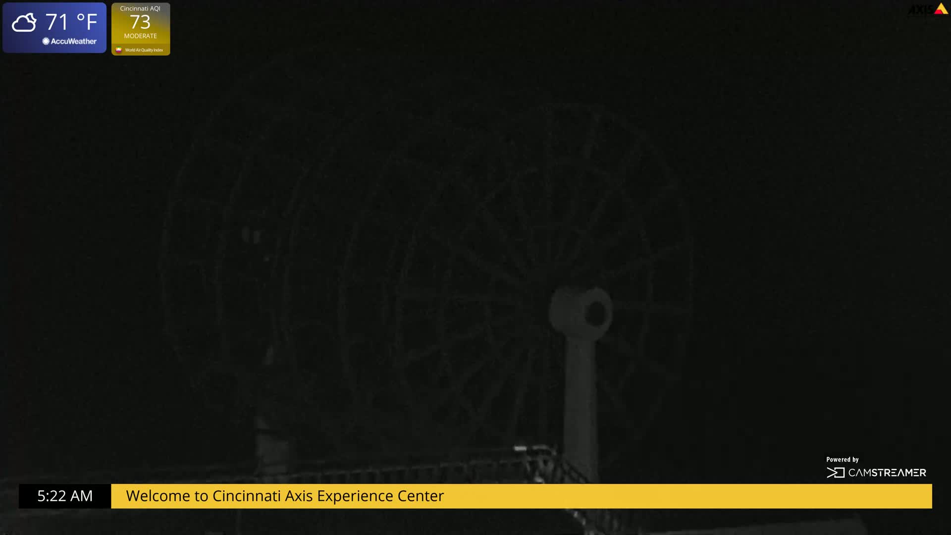 At night, a Ferris wheel is dimly visible against a dark sky.