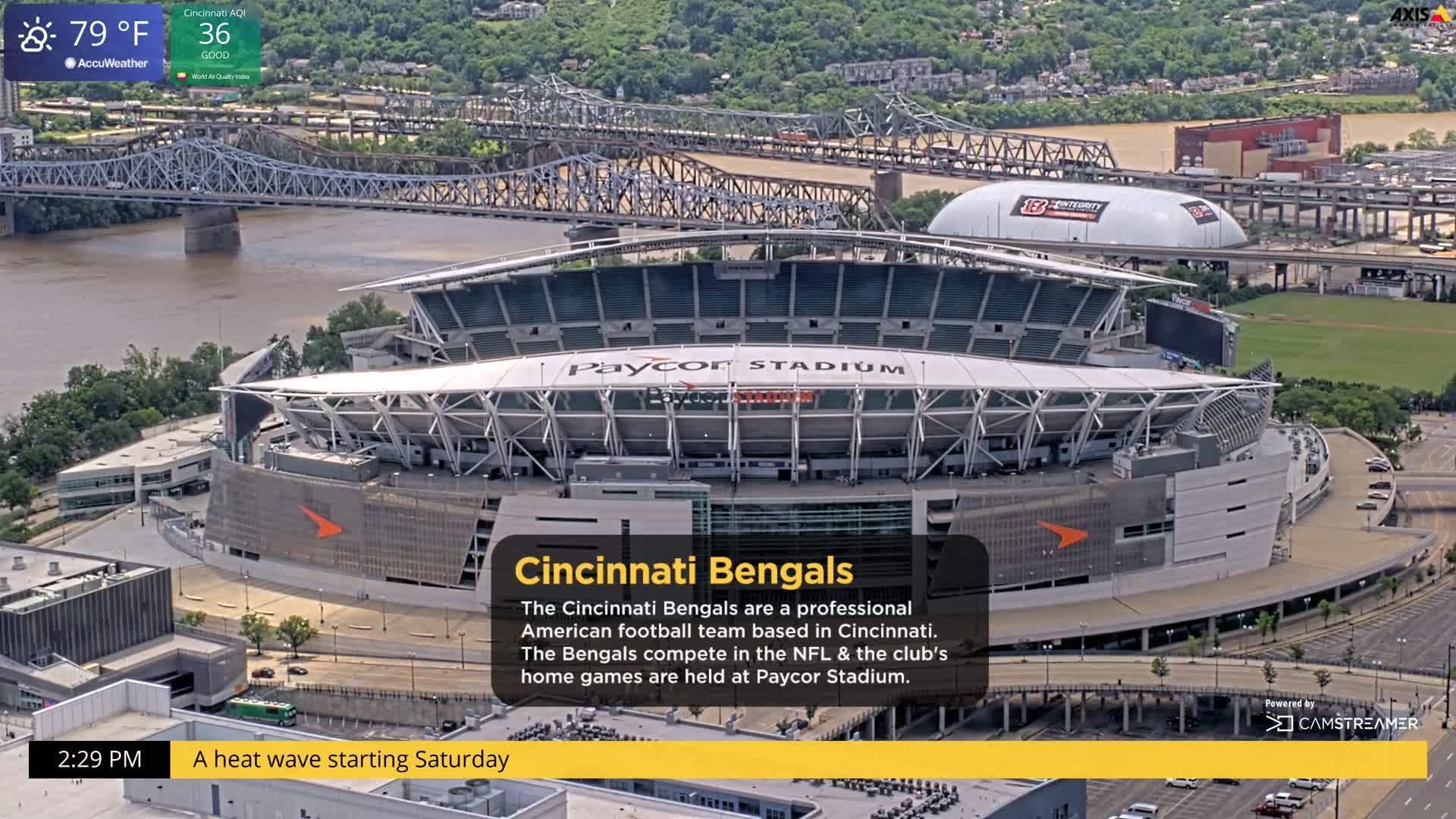 An aerial view shows Paycor Stadium on a partly sunny day next to a river and bridge.
