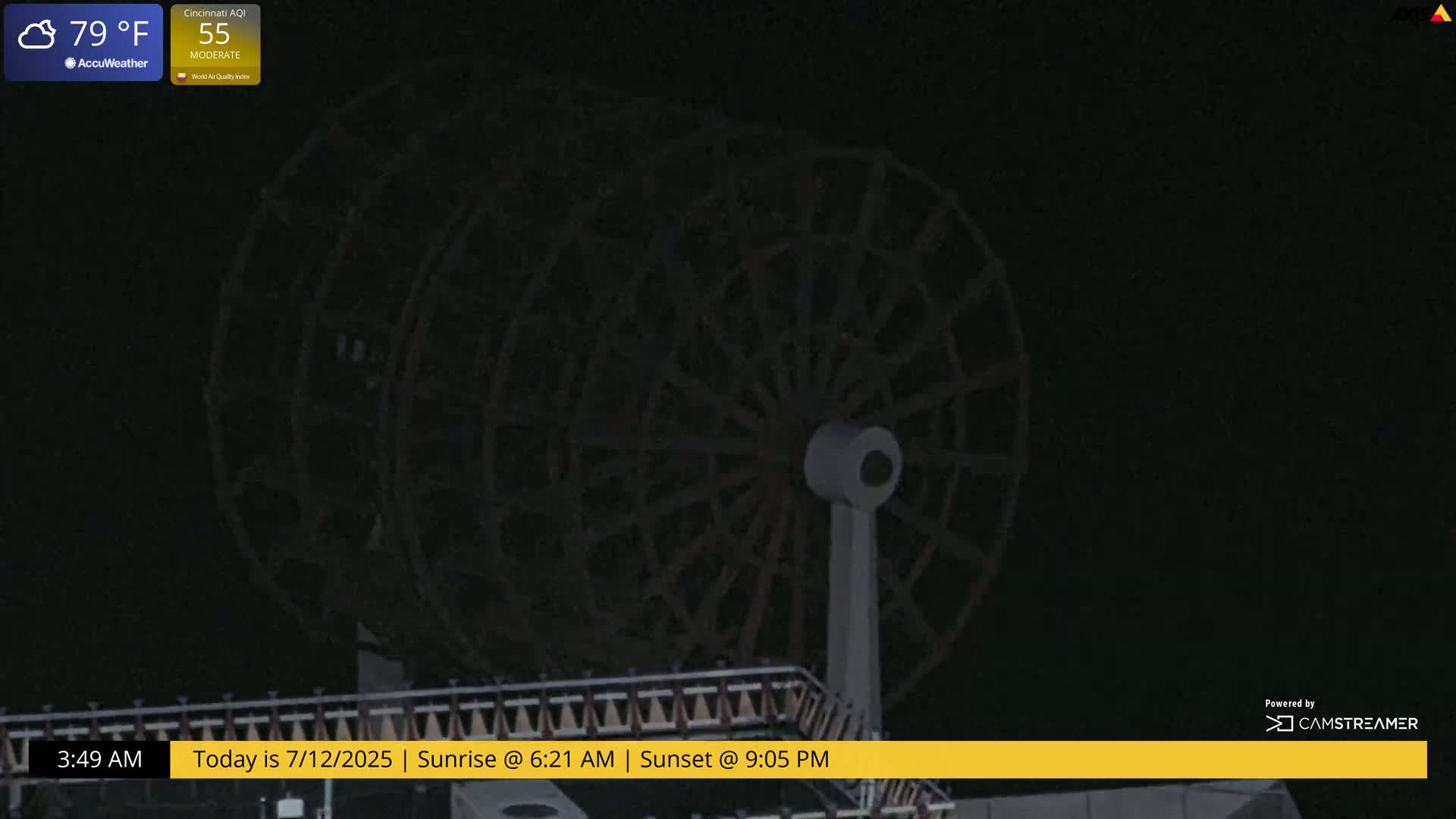 A dark, nighttime image shows a large Ferris wheel at rest.