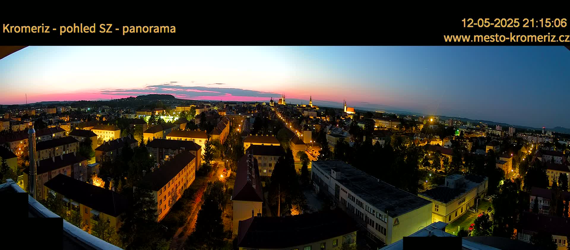 A panoramic view of a city at twilight, with the sky showing a blend of pink and blue hues.