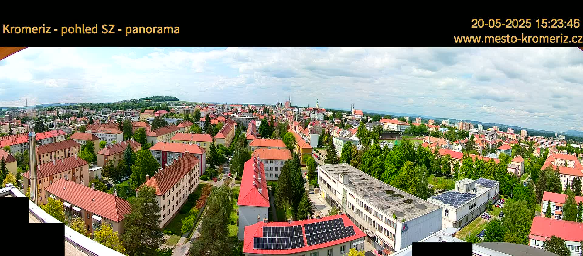 A panoramic view of a city with mostly red-roofed buildings on a partly cloudy day.
