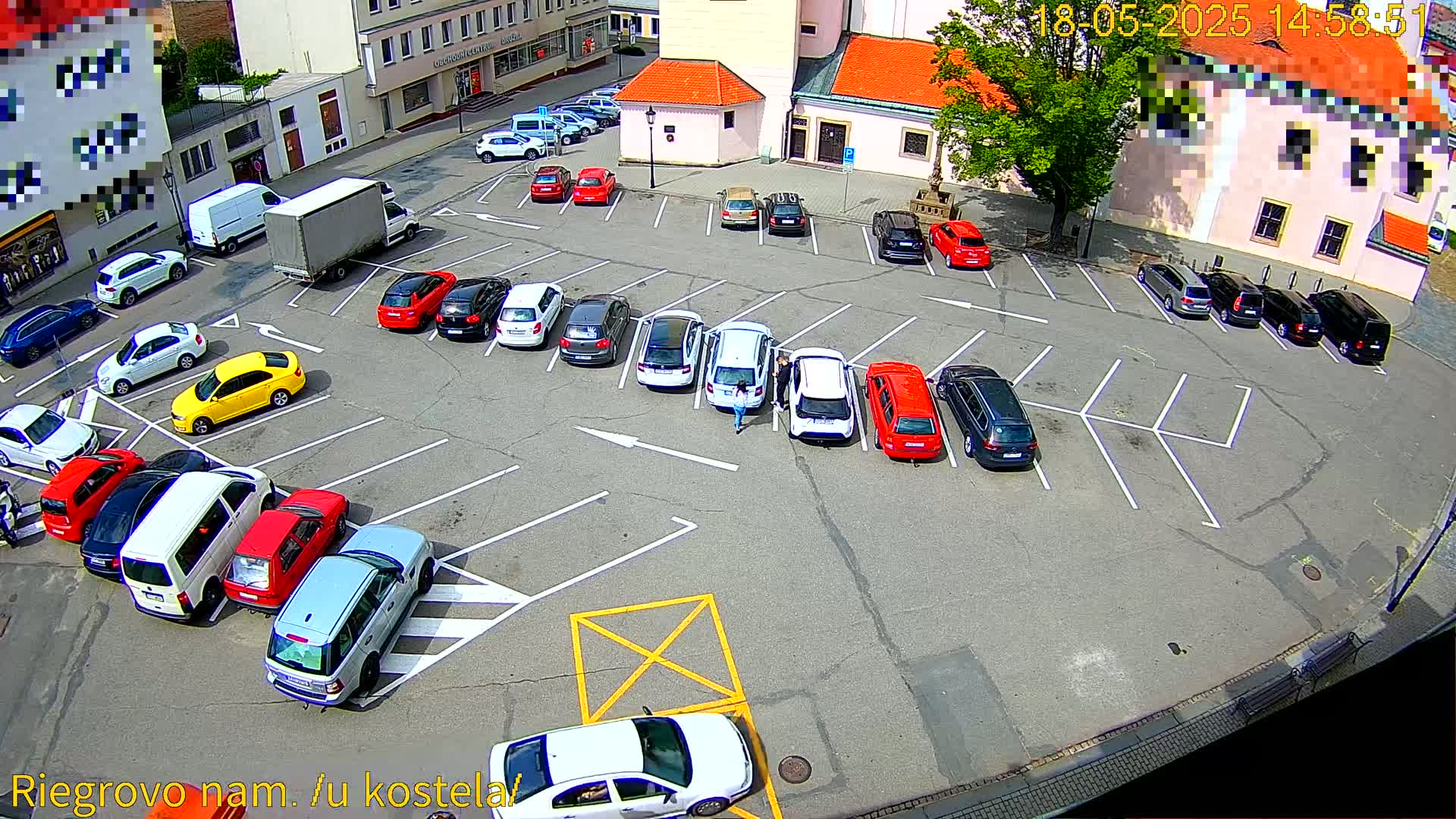 A parking lot filled with various cars under a sunny sky.