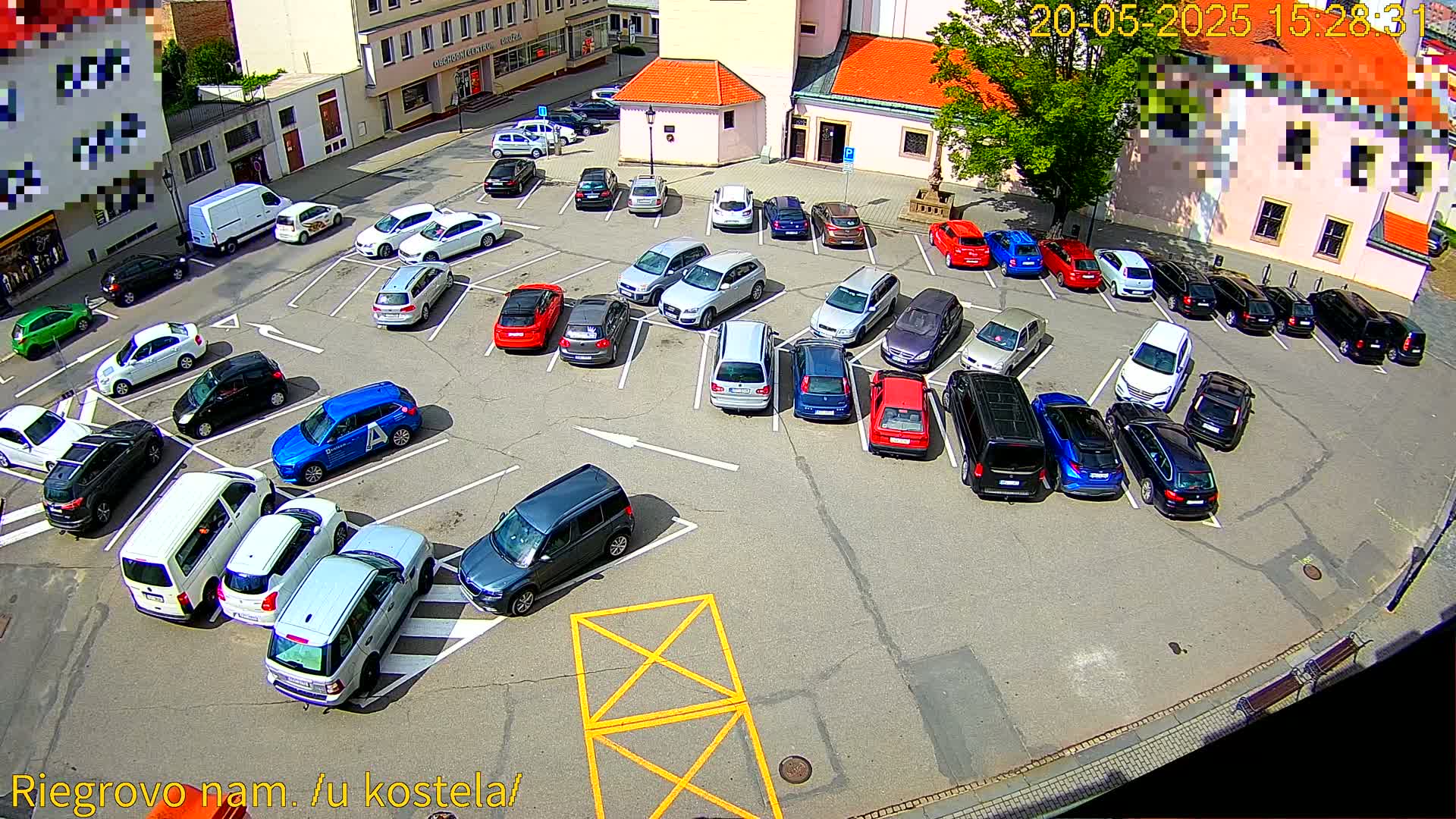 A parking lot filled with numerous cars of various colors and models under a sunny sky.
