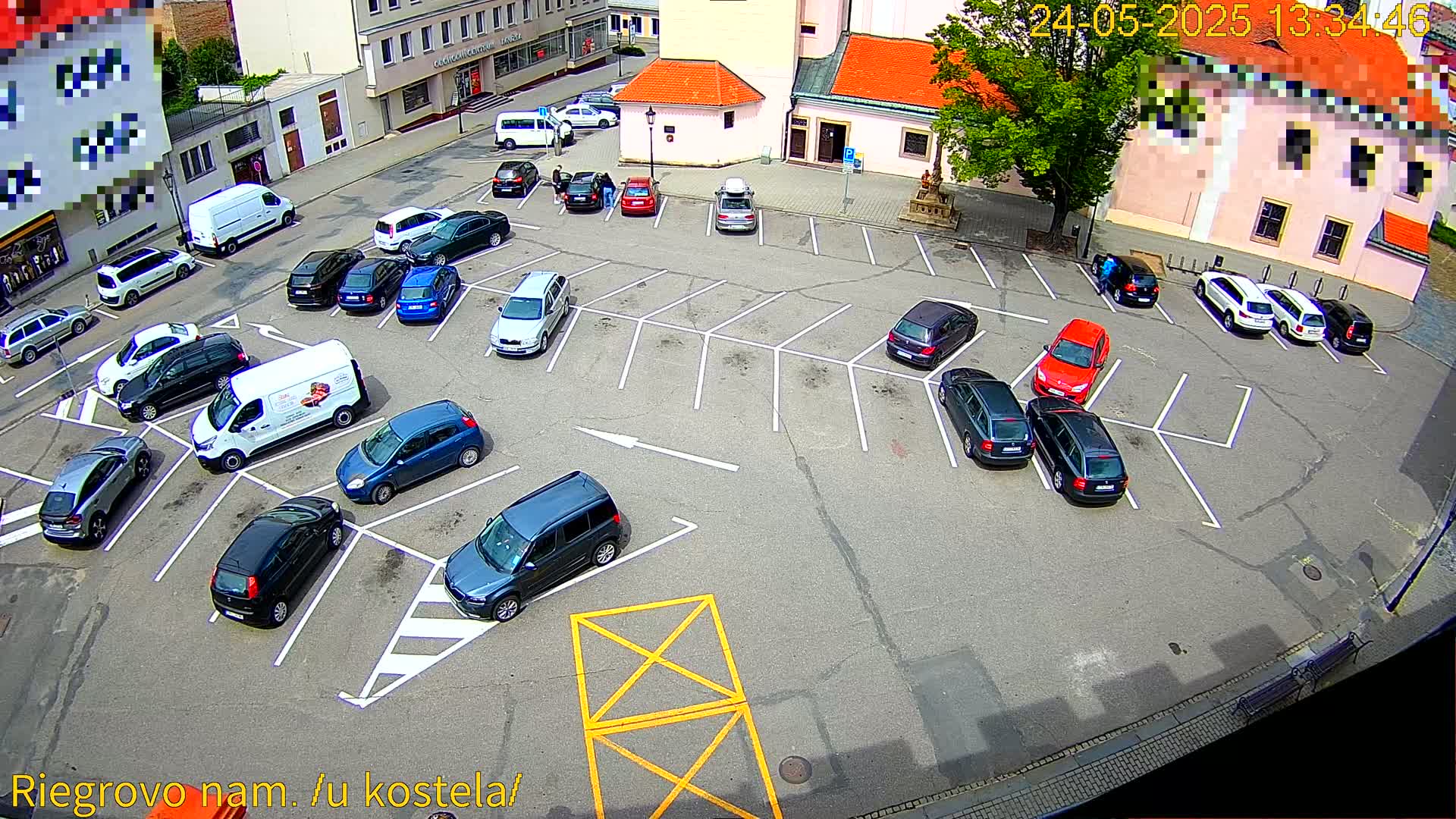 An outdoor parking lot with numerous cars parked in marked spaces on a sunny day.