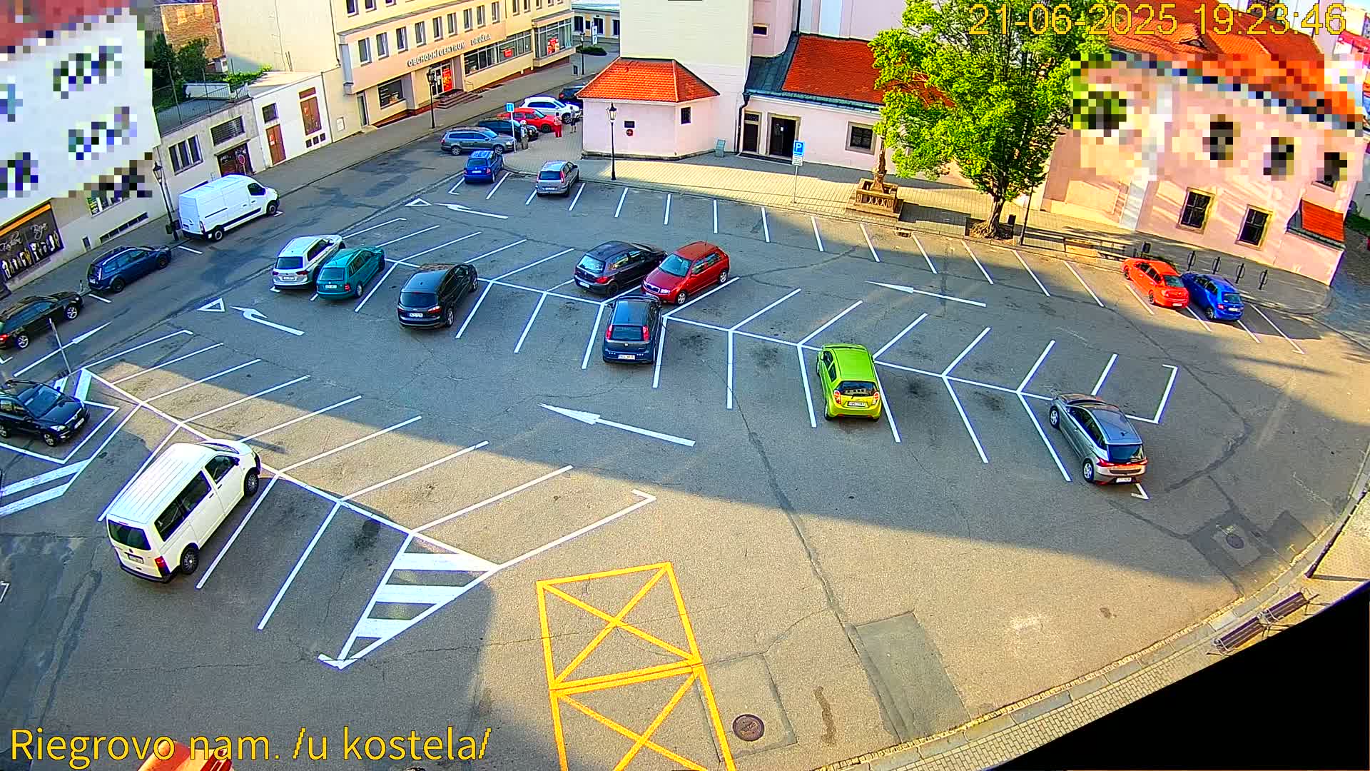 An asphalt parking lot with numerous cars parked in a sunny, outdoor setting.