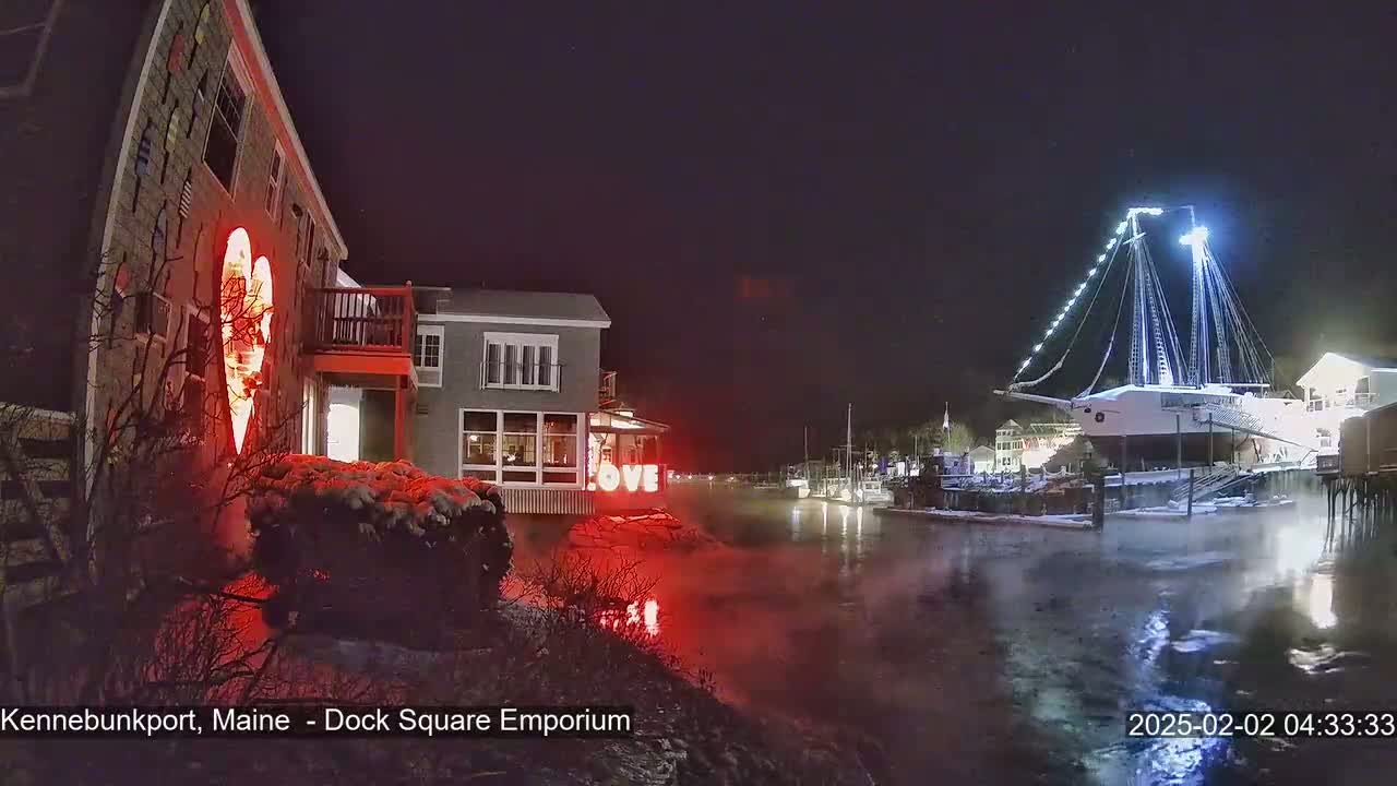 A nighttime waterfront scene shows a snow-covered building with a lighted heart and the word "LOVE," a large ship docked, and a waterway with steam rising from the water.