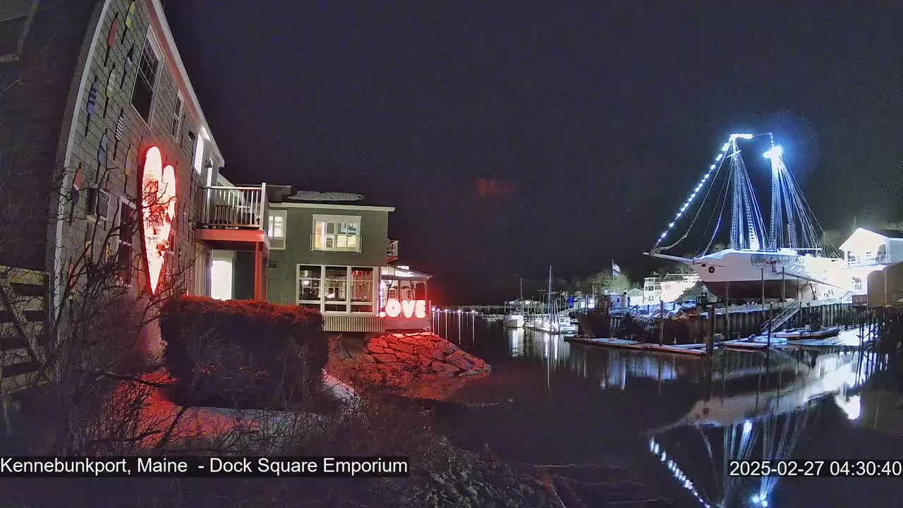 At night, a harbor scene shows a building with a large illuminated heart and the word "LOVE" on its exterior, near a large illuminated ship docked in the water.