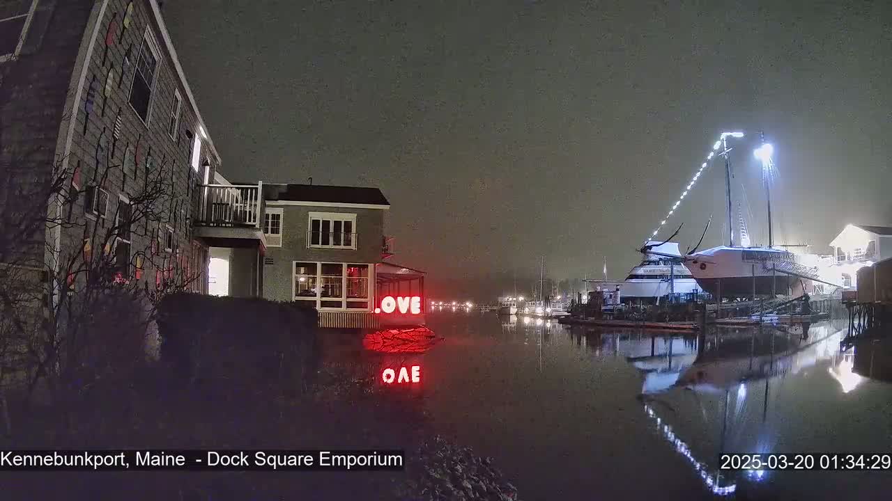 A nighttime scene shows a building with a "LOVE" sign, docked boats, and a calm, foggy waterway.