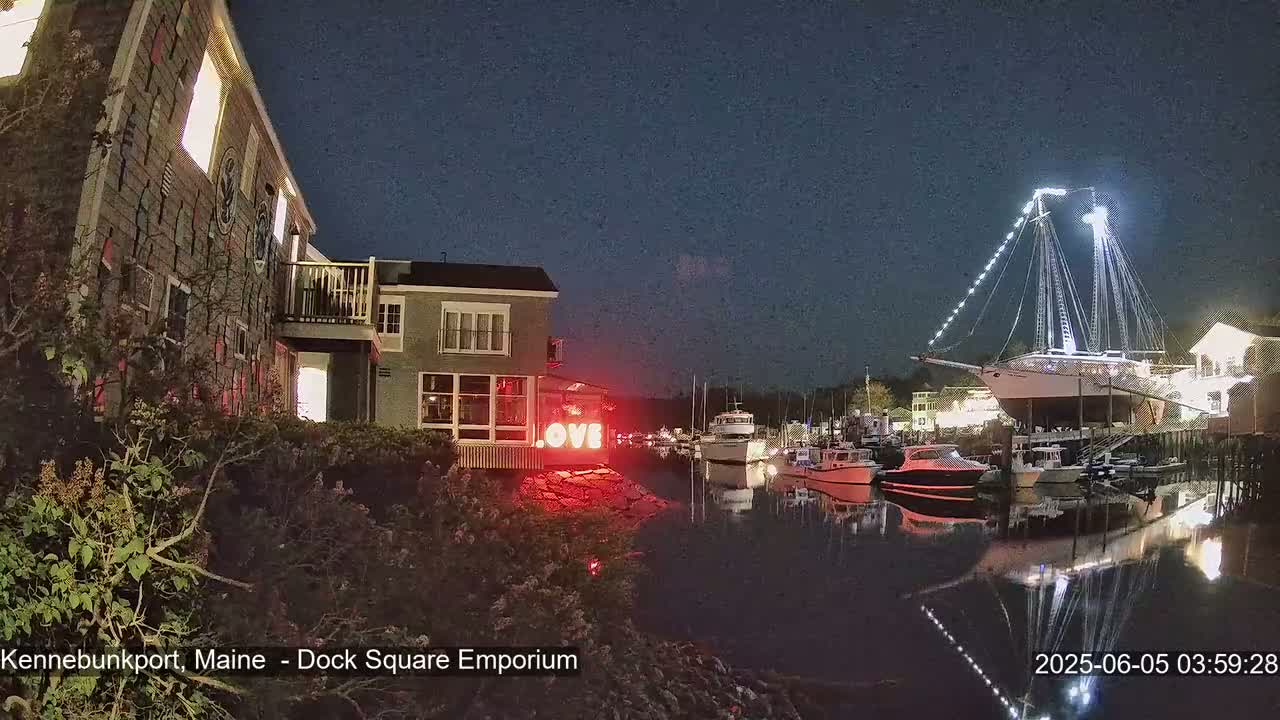 At night, a harbor scene shows a large sailing ship docked next to smaller boats, with a building displaying illuminated "LOVE" lettering visible near the water's edge.