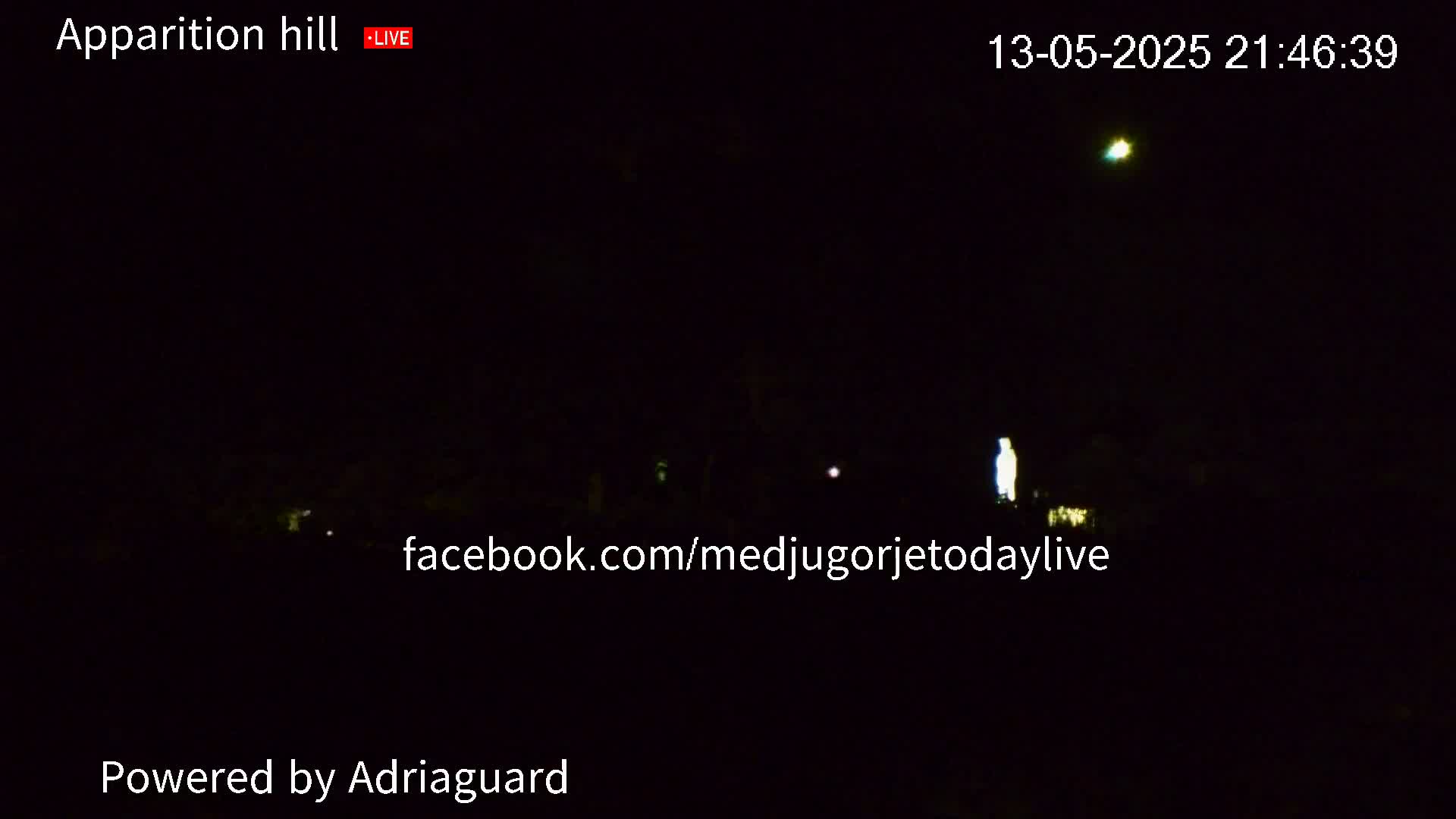 A dark, nighttime scene shows a dimly lit area with a single, bright figure standing in the center.