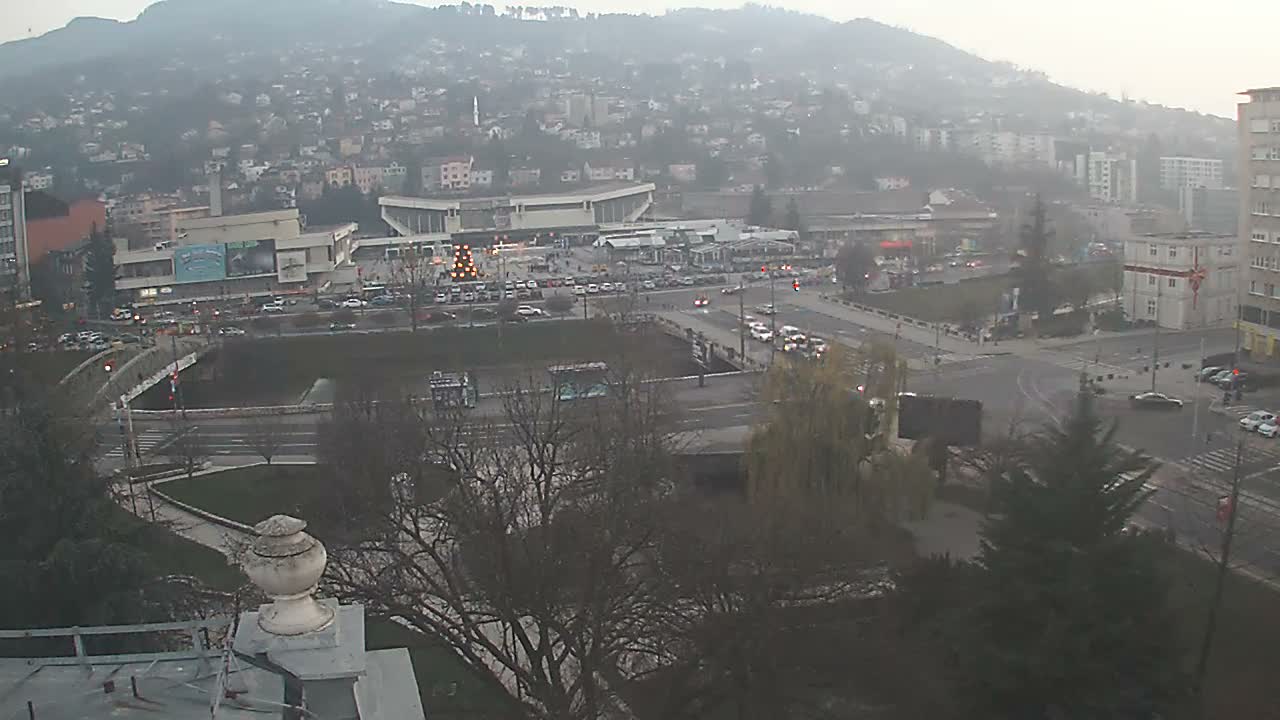 The image displays a clear, dark outdoor night scene of a city area with numerous illuminated buildings, streets with vehicle lights, and decorative lights, with the ground appearing wet but no active precipitation.