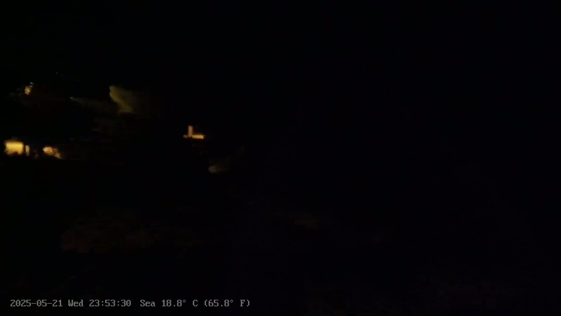 A nighttime, low-light image shows faintly lit structures and some indistinct shapes in the darkness, with a sea temperature of 18.8°C.