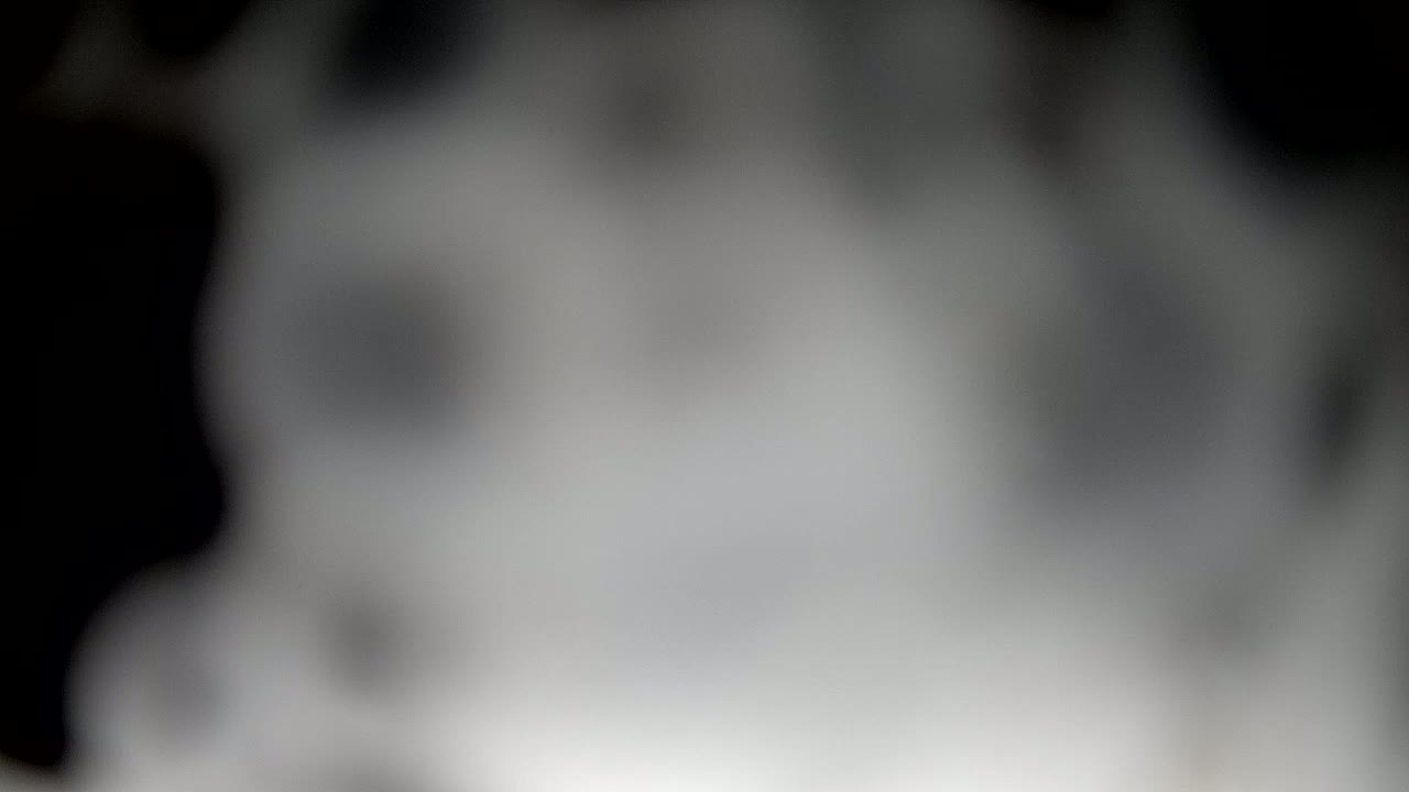 A blurry, out-of-focus image shows a grayscale cloud of smoke or fog.