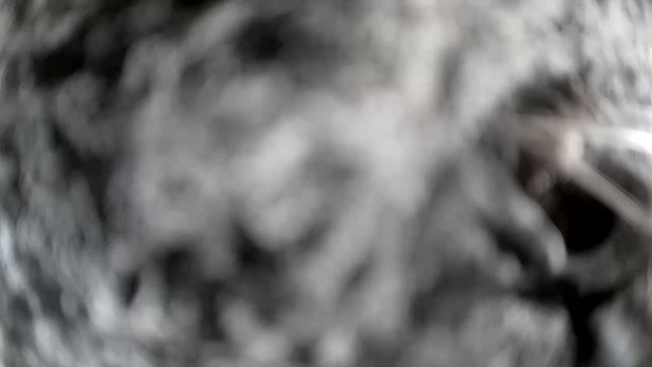 A blurry, out-of-focus image shows a mass of grey and white, possibly resembling a cloudy sky or a textured surface.
