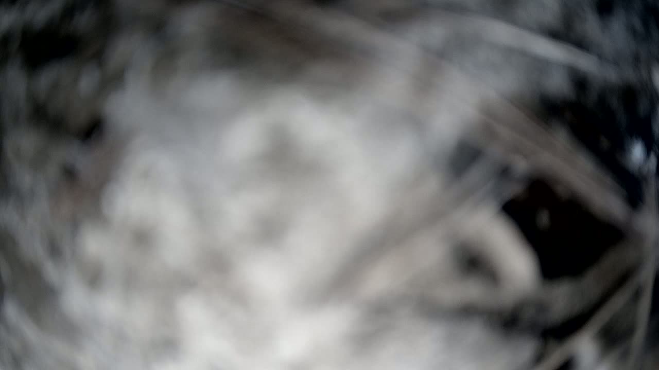 A blurry, out-of-focus image shows a swirling mass of gray and white, possibly smoke or clouds.