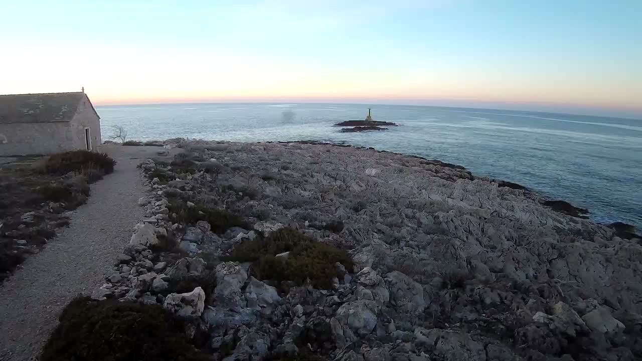An uneven, dimly lit terrain covered in what appears to be snow or ice extends into a dark, hazy distance under the conditions of a cold night.