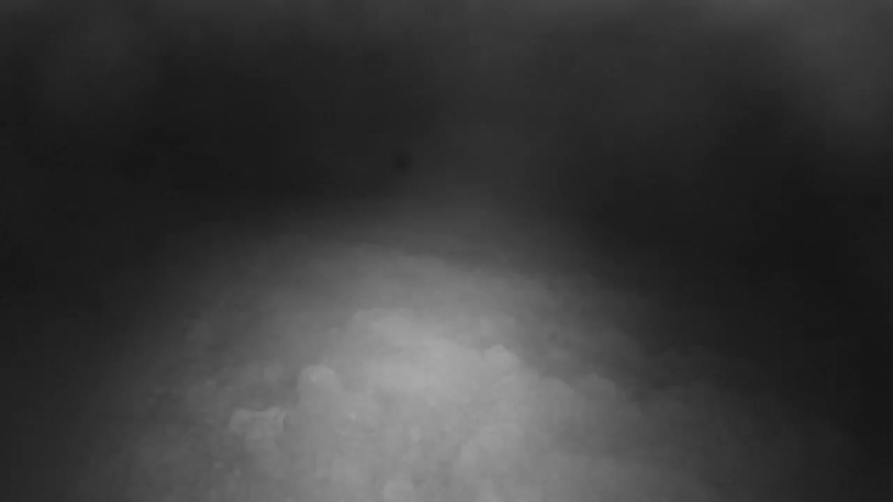 An uneven, dimly lit terrain covered in what appears to be snow or ice extends into a dark, hazy distance under the conditions of a cold night.