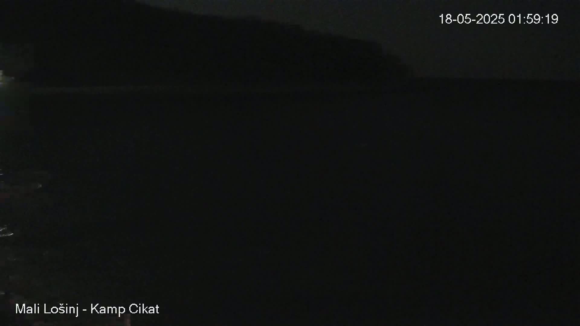 A dark nighttime image shows a body of dark water under a dark sky.