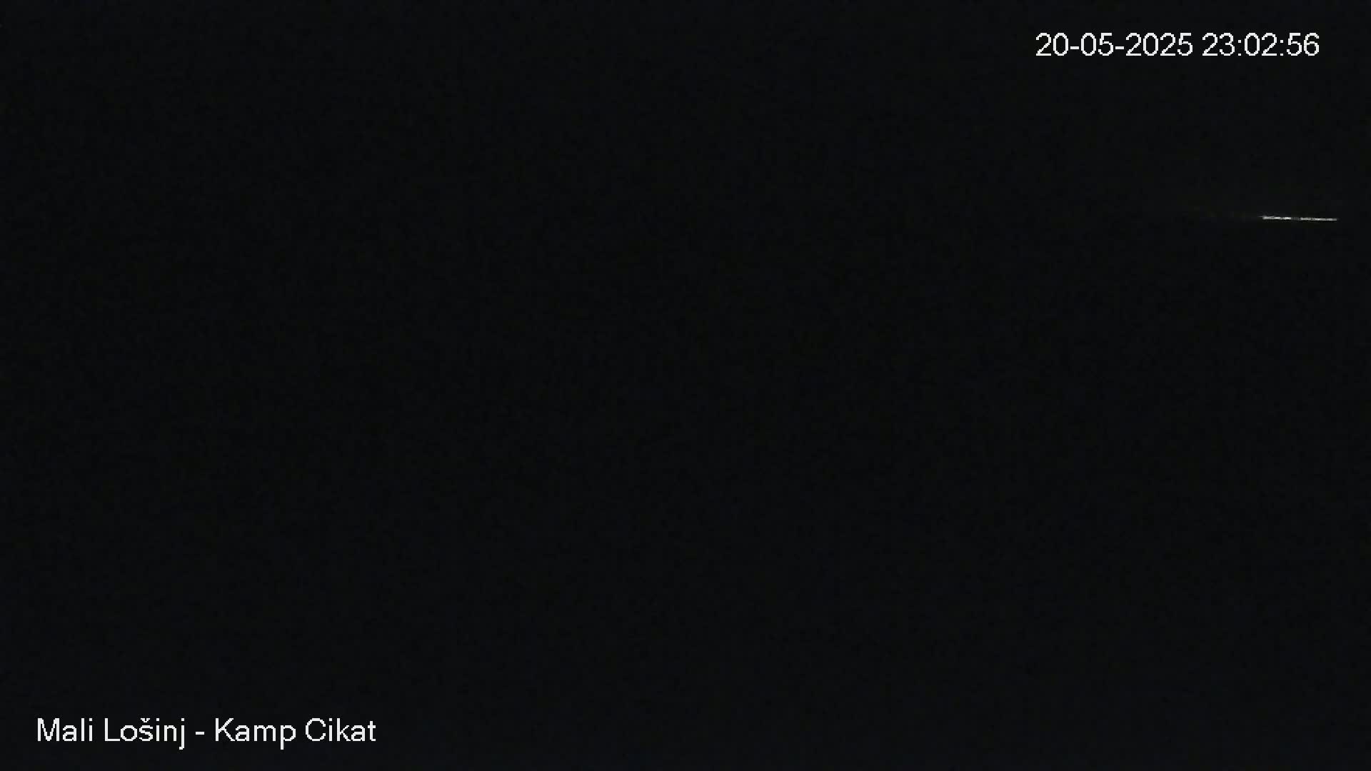 A dark, nighttime scene shows a faint, horizontal line of light in the distance.
